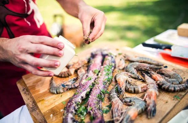 Unrecognizable man preparing seafood for a barbecue grill in the backyard. Close up. — Stock Photo, Image