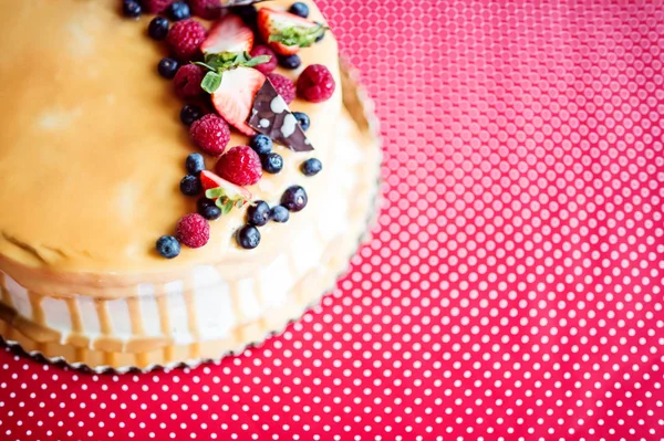 A birthday cake on a glass stand on the table, fruit on top. Top view. — Stock Photo, Image