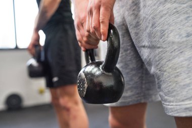 Kettlebell salıncaklar yapıyor spor salonunda tanınmaz halde genç erkekler.