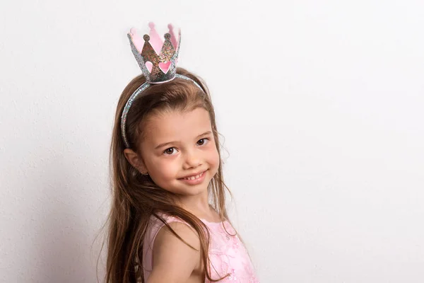 Retrato de uma menina pequena com a cabeça da coroa em estúdio em um fundo branco . — Fotografia de Stock