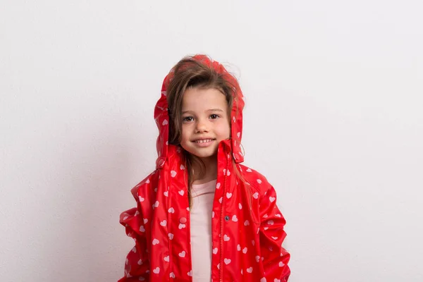 Ritratto di bambina con anorak rosso in studio su sfondo bianco . — Foto Stock