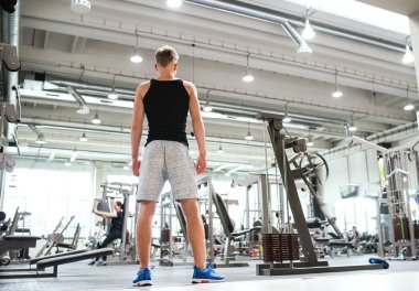 Genç adam ayakta modern crossfit salonunda. Arkadan Görünüş.