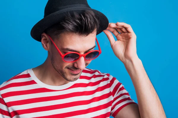 Retrato Joven Estudio Con Gafas Sol Sombrero Sobre Fondo Azul —  Fotos de Stock