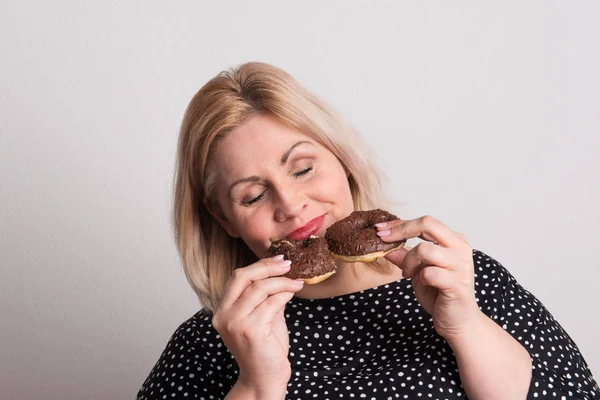 İki donut tutan bir çekici kilolu kadın Studio,. — Stok fotoğraf