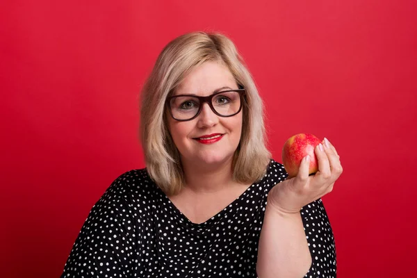 Bir elma elinde tutan bir çekici kilolu kadın Studio,.