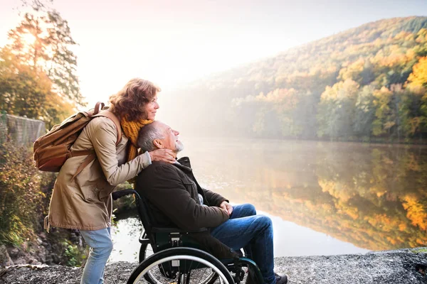 Pareja mayor con silla de ruedas en otoño . — Foto de Stock