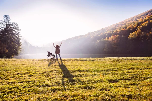 秋の自然の中車椅子で立っている年配の女性. — ストック写真