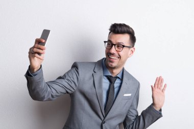 Selfie alarak smartphone bir stüdyoda olan genç bir adam portresi.