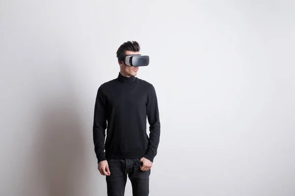 Portrait of a young man with virtual reality goggles in a studio. — Stock Photo, Image