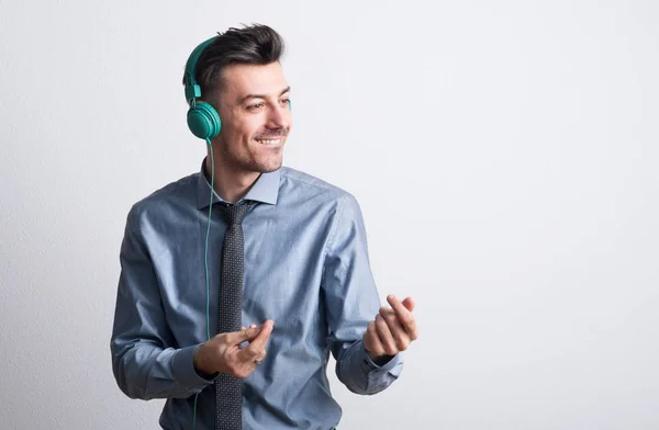 Portrait d'un jeune homme joyeux avec écouteurs dans un studio, dansant . — Photo