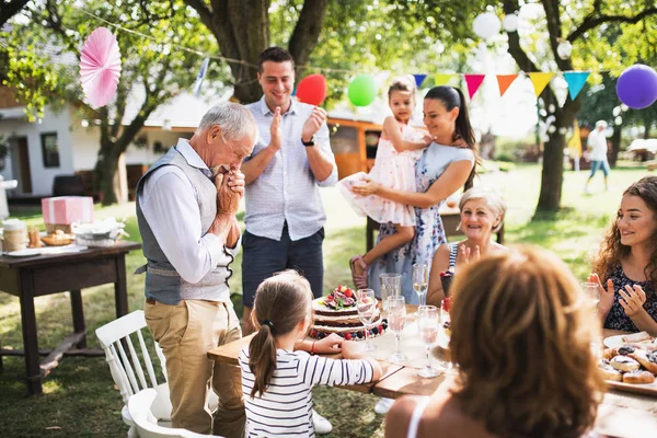 A senior man with an extended family looking at the birthday cake, crying. — Stock Photo, Image