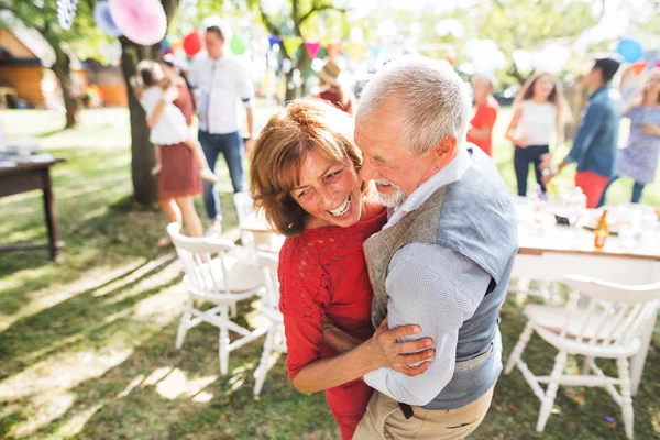 A senior couple dancing on a garden party outside in the backyard. — Stock Photo, Image