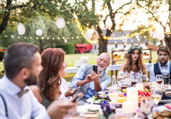 家の裏庭に外の結婚披露宴で selfie を取って年配の男性. — ストック写真