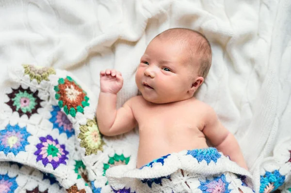 Yeni doğan bebek yatak, tığ işi battaniye ile örtülü yatan. Üstten görünüm. — Stok fotoğraf