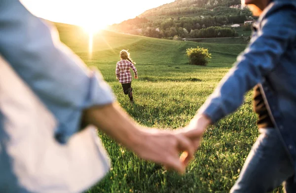 Una bambina con i suoi nonni anziani che si divertono all'aperto nella natura al tramonto . — Foto Stock