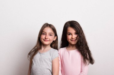 İki küçük kız bir stüdyoda ayakta.