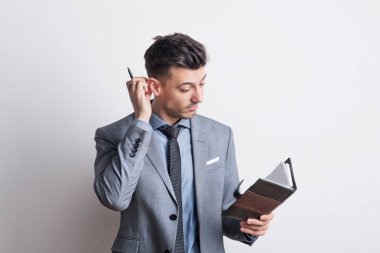 Bir stüdyoda bir akıllı telefon ile düşünceli genç bir adam portresi.