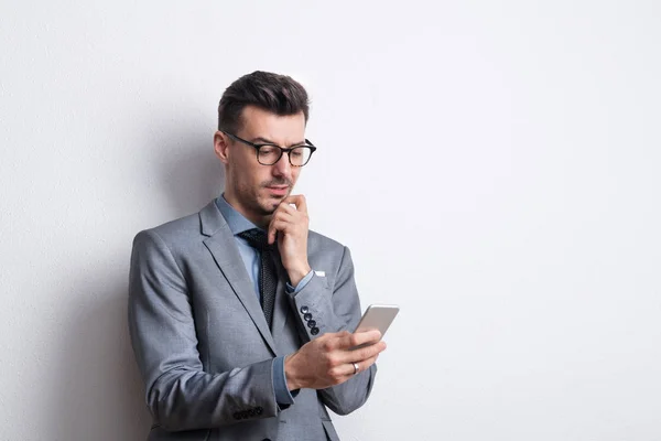 Portrait of a thoughtful young man with a pen and a diary in a studio, planning. — Stock Photo, Image