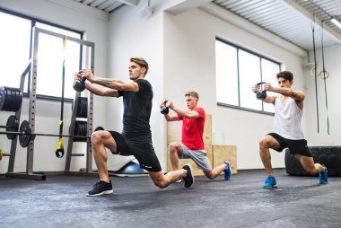 Ireland ile egzersiz yaparak spor salonunda üç genç adam.