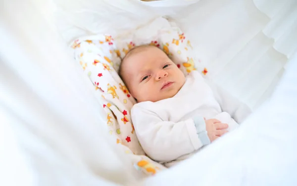 Yatakta yatarken şirin mutlu yeni doğan bebek. — Stok fotoğraf