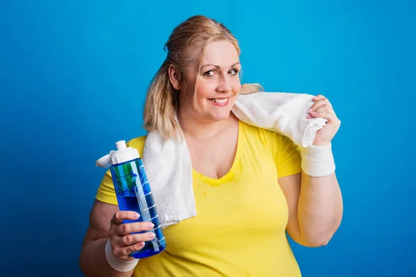 Portrét šťastné obézní ženy s láhev s vodou ve studiu. — Stock fotografie