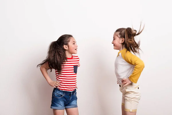 Piccole ragazze in piedi in uno studio, guardarsi l'un l'altro . — Foto Stock