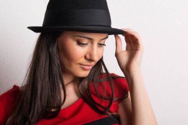 Güzel bir genç kadın bir stüdyoda siyah şapkalı bir close-up.