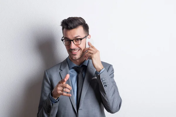 Portret van een jonge man met smartphone in een studio, een telefoongesprek maken. — Stockfoto