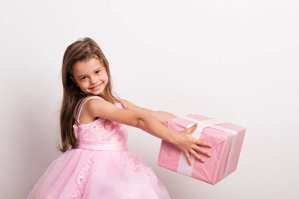 Ritratto di una bambina in studio, con in mano una scatola avvolta . — Foto Stock