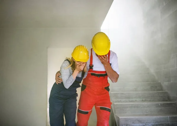Жінки і чоловіки, які страждають на будівельному майданчику . — стокове фото