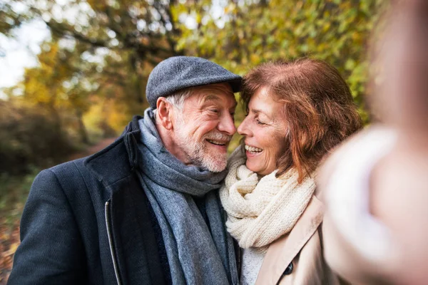 Äldre par i kärlek i en höst natur, tar selfie. — Stockfoto