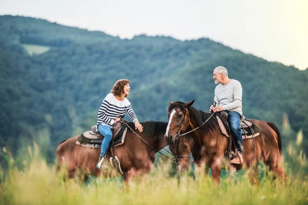Una coppia di anziani a cavallo nella natura . — Foto Stock