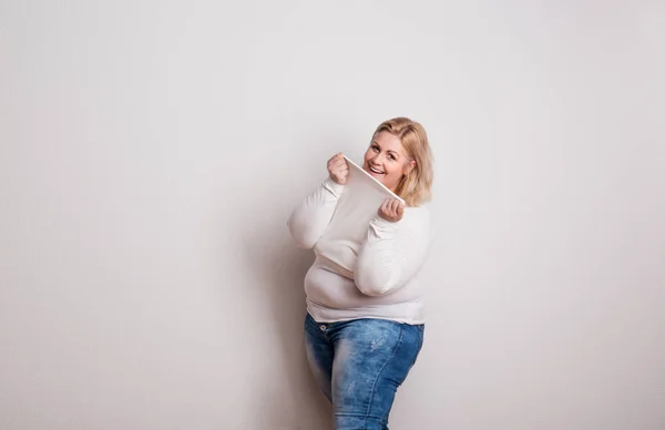 Retrato de uma mulher com sobrepeso atraente em estúdio em um fundo branco . — Fotografia de Stock