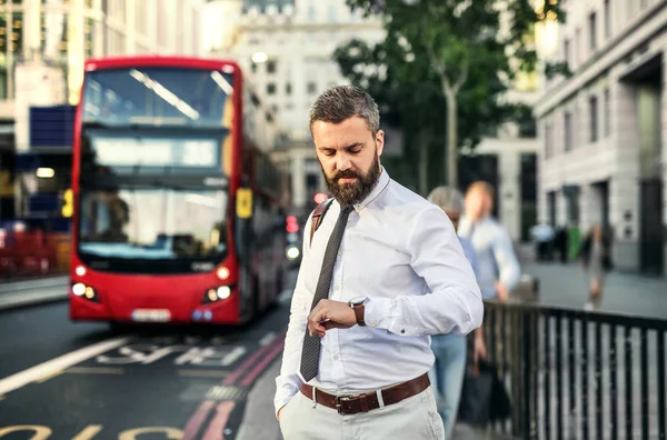流行に敏感なビジネスマン、ロンドンでバスを待っている時間をチェック. — ストック写真
