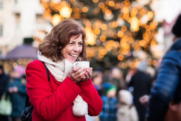 Senior woman on an outdoor Christmas market. — Stock Photo, Image