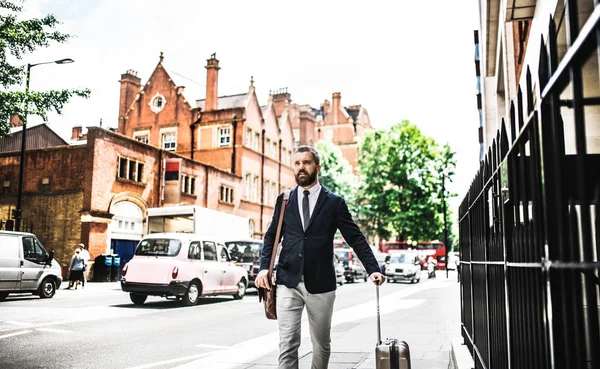 Hipster hombre de negocios con maleta caminando por la calle en Londres . — Foto de Stock