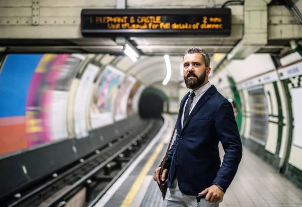 Uomo d'affari hipster con una borsa in attesa del treno in metropolitana . — Foto Stock