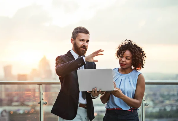 Porträt von Geschäftsleuten mit Laptop vor dem Sonnenuntergang von London. — Stockfoto