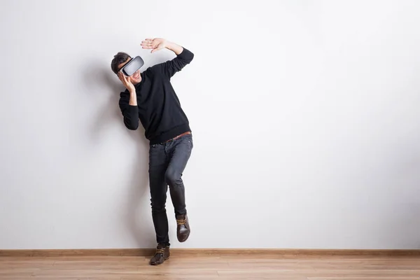 Retrato de un joven con gafas de realidad virtual en un estudio. Copiar espacio . — Foto de Stock