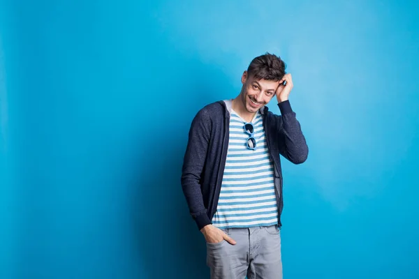 Porträtt av en glad ung man som bär casual kläder i en studio. — Stockfoto