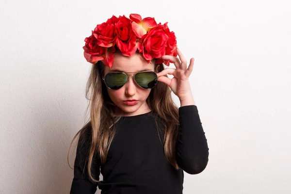 Маленькая девочка с повязкой из красного цветка и солнцезащитными очками в студии . — стоковое фото