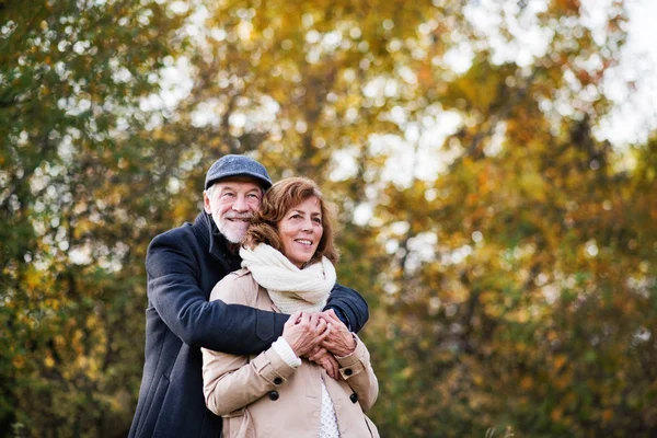 秋の自然の中に年配のカップル立ってハグ. — ストック写真