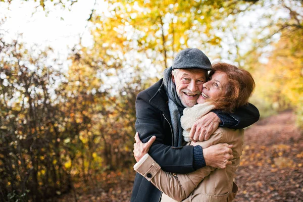 Vedoucí pár stojící v podzimní přírodě, objímání. — Stock fotografie