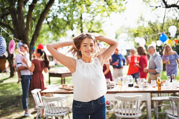 Una adolescente en una celebración familiar o una fiesta en el jardín afuera . —  Fotos de Stock
