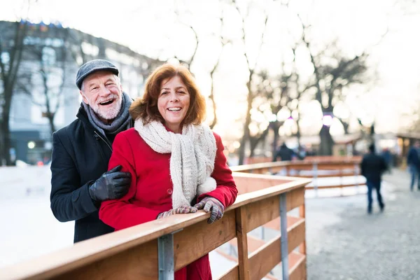 Senior paar op een wandeling in een plaats (city) in de winter. — Stockfoto