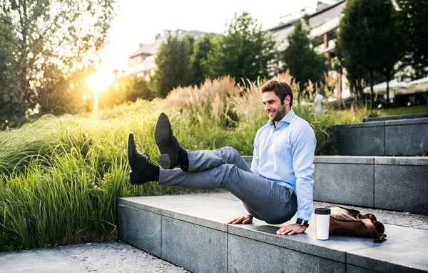 En glad affärsman utomhus på trapporna vid solnedgången., handstående i L-sit position. — Stockfoto