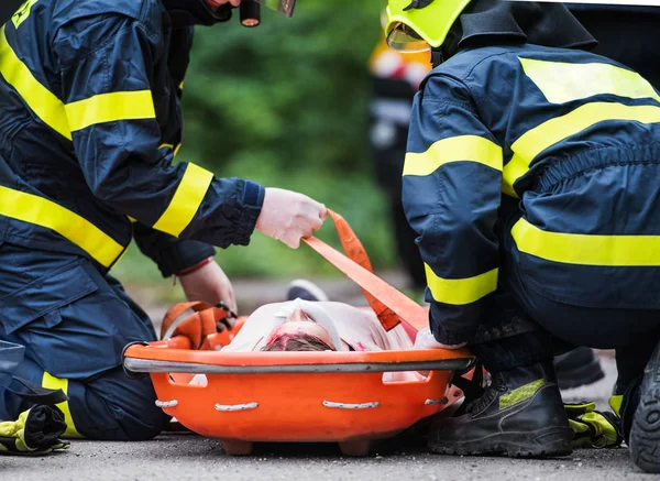 Pompierii au pus o femeie rănită într-o targă de plastic după un accident de mașină . — Fotografie, imagine de stoc