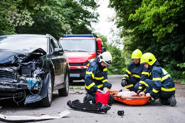 Pompierii ajută o tânără rănită după un accident de mașină . — Fotografie, imagine de stoc