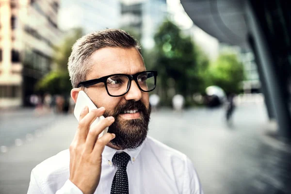 Крупный план хипстерского бизнесмена со смартфоном в городе, делающего телефонный звонок . — стоковое фото