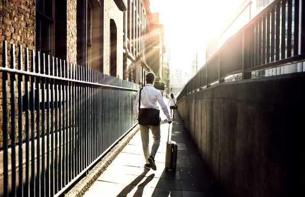 Achteraanzicht van zakenman met koffer lopen de straat in Londen. — Stockfoto